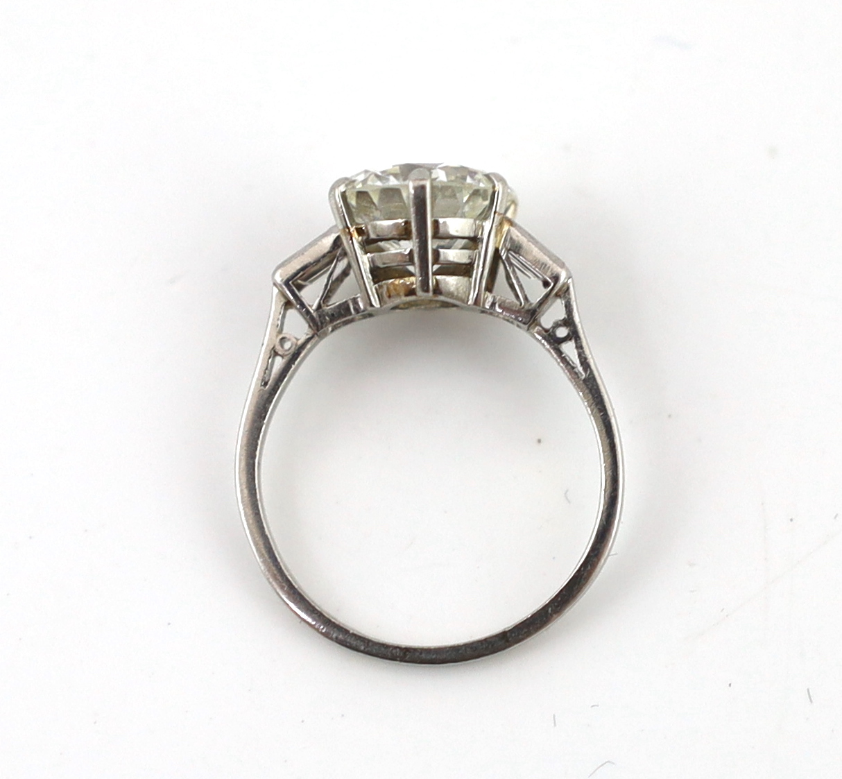 A good platinum or white gold set single stone diamond ring, with two stone baguette cut diamond set shoulders